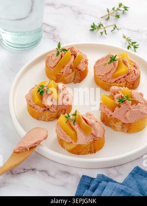 Gourmet liver pâté crostini with peaches and thyme Stock Photo