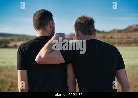 A male couple shares an intimate moment outdoors. Stock Photo