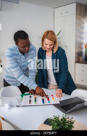 Diverse designers collaborating on color palette during meeting Stock Photo