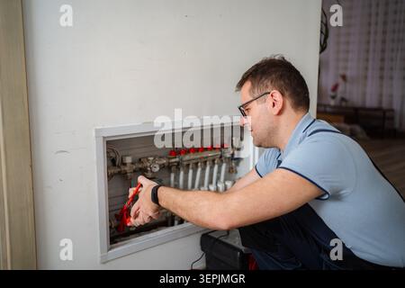 Plumber adjusting heating system pipes in home Stock Photo