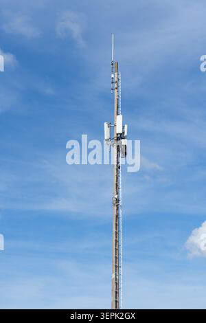 Telecommunication tower with antennas against blue sky Stock Photo