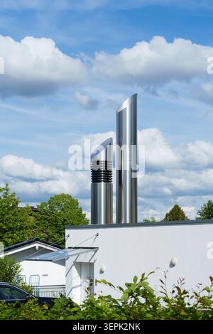 Modern ventilation pipes on rooftop against blue sky Stock Photo