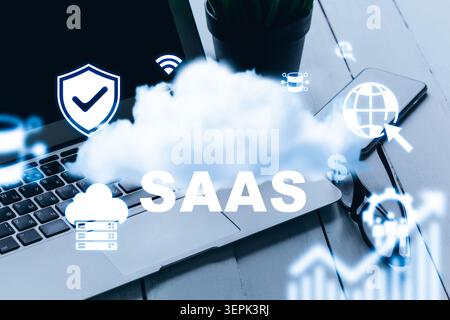 Saas logo on laptop with cloud images and internet icons during work session Stock Photo