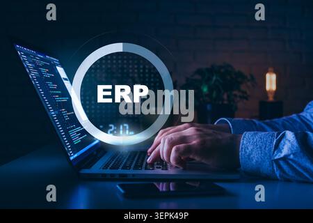 Working on ERP system to manage business operations in a dark office setting Stock Photo