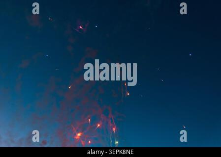 Colorful festive pyrotechnics fireworks burst celebrating New Year or Independence Day. Vibrant multi-color fireworks exploding against a dark blue tw Stock Photo