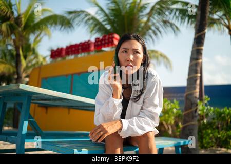 Conceptual image of a modern nomad balancing remote connection with a tropical escape Stock Photo