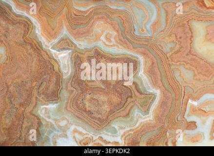 Onyx marble stone, crossed cut. Main colors are brown, orange, green and white. Texture and background. Stock Photo