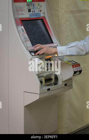 Kyoto, Japan April 20, 2026 hand interacting with ticket vending machine touchscreen during payment process in railway station Stock Photo