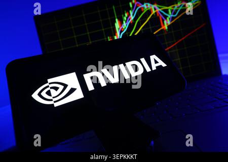 NVIDIA Logo on Smartphone Screen With Stock Market Performance Chart on Computer Stock Photo