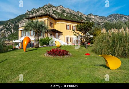 Modern abstract colorful sculptures displayed on the green lawn in front of the Municipio town hall building, Limone sul Garda, Italy Stock Photo