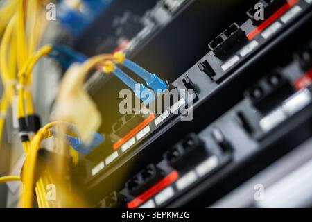 Fiber patch panel with connected optical cables in a server rack data center Stock Photo