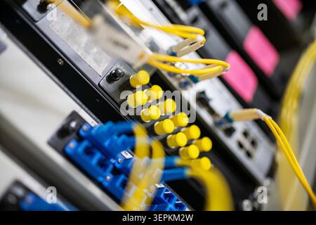 Fiber patch panel with connected optical cables in a server rack data center Stock Photo