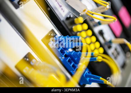Fiber patch panel with connected optical cables in a server rack data center Stock Photo