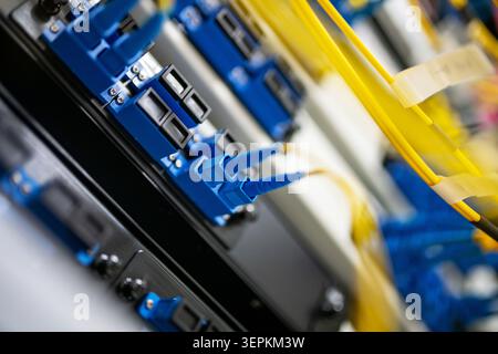 Fiber patch panel with connected optical cables in a server rack data center Stock Photo