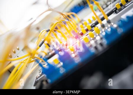 Fiber patch panel with connected optical cables in a server rack data center Stock Photo