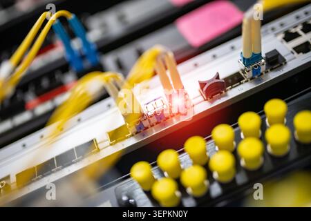 Fiber patch panel with connected optical cables in a server rack data center Stock Photo