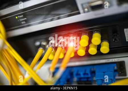 Fiber patch panel with connected optical cables in a server rack data center Stock Photo