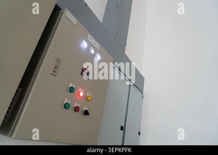 This image features an industrial control panel equipped with various switches, buttons, and indicator lights, used to manage and monitor electrical s Stock Photo