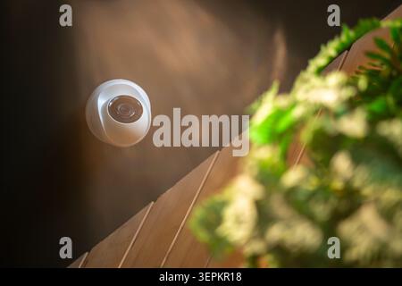 This image features a modern security camera installed outdoors on the exterior of a building, emphasizing home security and surveillance technology f Stock Photo