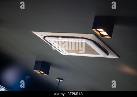 This image features a modern air conditioning unit installed in a ceiling with built-in spotlights, demonstrating contemporary interior design and cli Stock Photo