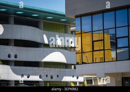 A modern building with unique architectural design featuring glass windows, sleek curves, and diverse materials that reflect innovation and urban deve Stock Photo