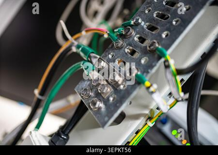 Close-up of an electrical circuit panel featuring multiple colorful wires connected to various metal terminals, illustrating complex electrical wiring Stock Photo