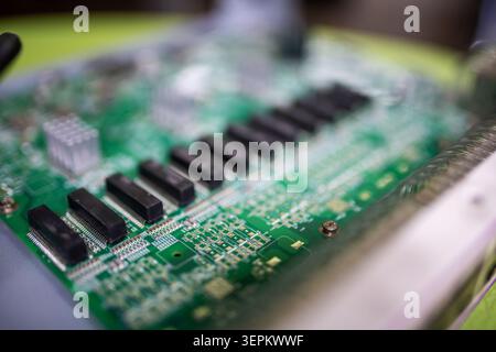 This close-up image showcases a detailed electronic circuit board featuring various microchips, electronic components, circuitry lines, and connection Stock Photo