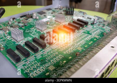 A detailed close-up of a green printed circuit board showcasing heat sinks, connectors, and electronic components used in modern electronic devices. Stock Photo