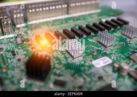 Close-up image of a printed circuit board featuring various electronic components including heatsinks, chips, and connectors, highlighting modern tech Stock Photo