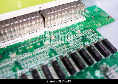 Close-up of a green printed circuit board with connected ports and electronic components, showcasing detailed circuitry used in electronic devices and Stock Photo