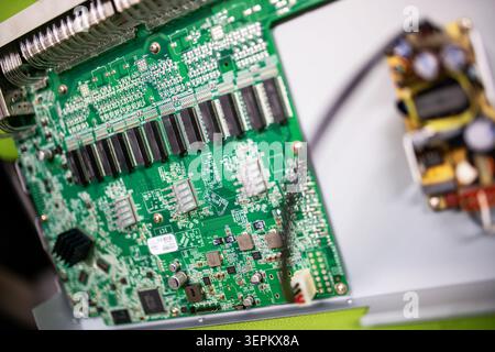 Close-up of a green printed circuit board with an array of microchips, resistors, and electronic components designed for electronic device assembly an Stock Photo