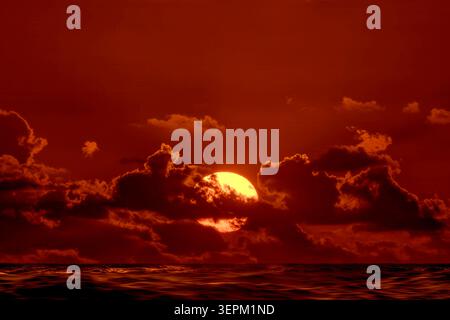 Sun rising through clouds over Atlantic Ocean Stock Photo
