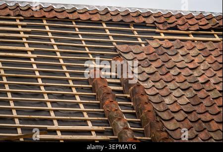 Clay roof tile repair and replacement on old house during roof renovation Stock Photo