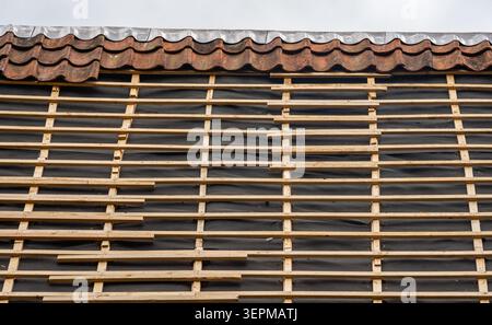 Clay roof tile repair and replacement on old house during roof renovation Stock Photo