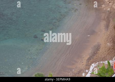 Waves hitting the shore near clear water in the afternoon Stock Photo