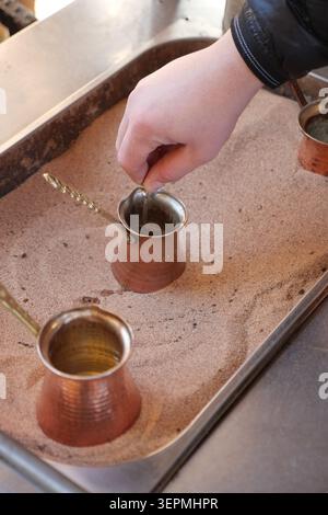 Preparing turkish coffee in a traditional method using hot sand Stock Photo