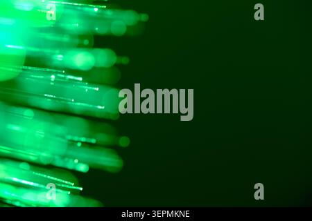 Horizontal glowing green fiber optic strands moving from left to right side Stock Photo
