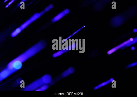 Sparse glowing blue and purple light dashes scattered across deep dark texture background Stock Photo