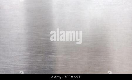High-resolution macro shot of a brushed stainless steel metal surface with fine linear texture and subtle light reflections for industrial design back Stock Photo