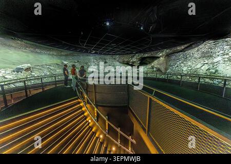 Visitors stand on a viewing platform overlooking a replica scree and glacial landscape at the Hohe Tauern National Park Worlds (Nationalparkwelten Hohe Tauern) in Mittersill. The 360-degree projection gives an impression of the high-alpine terrain in the Hohe Tauern National Park. Gerlos Straße, Klausen, Schattberg, Mittersill, Bezirk Zell am See, Salzburg, 5730, Austria Stock Photo