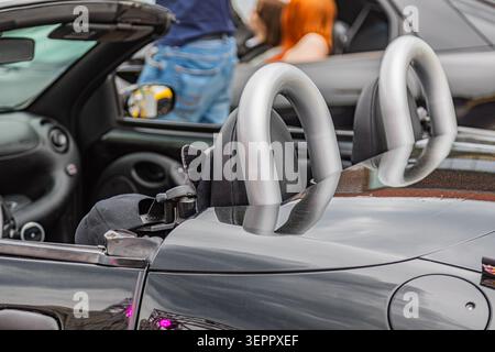 Convertible car interior with dark upholstered seats and metallic headrests showcasing sleek design elements and durable storage compartment for folde Stock Photo