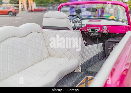 Classic convertible interior featuring white quilted seats with pink stitching enhancing retro aesthetic and luxurious texture including soft material Stock Photo