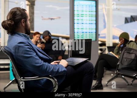 Professional using artificial intelligence and machine learning tools on computer in airport lounge, analyzing big data and algorithm performance. Business trip concept with modern workflow. Stock Photo