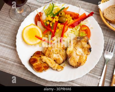 Oven baked hake with vegetable garnish Stock Photo