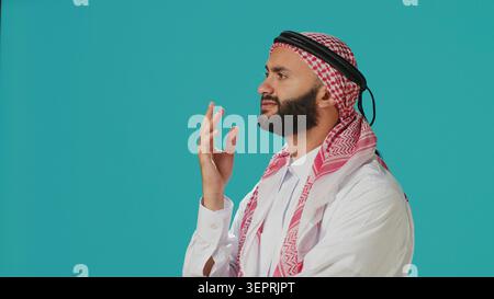 Middle Eastern guy being contemplative and thinking about new innovative ideas, being interested in a subject and trying to find answer, young person being thoughtful and uncertain in studio. Stock Photo