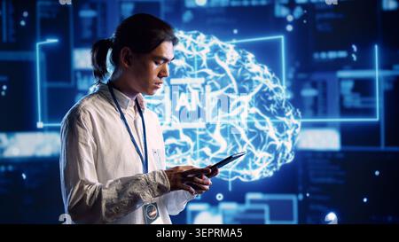 Focused technician in data center using artificial intelligence computing simulating human brain thought processes. Server room employee works on tablet with AI machine learning algorithms Stock Photo