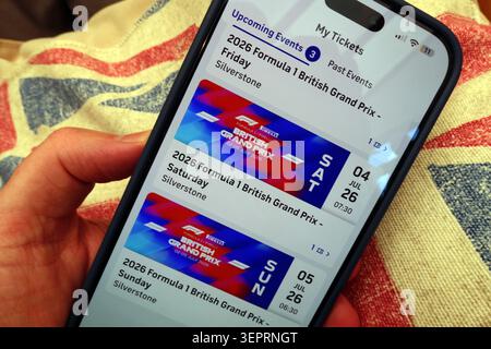 Silverstone F1 GP 2026 app tickets for the British Grand Prix displayed on an iPhone over a Union Jack, UK. Stock Photo