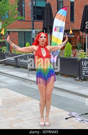 Fire eater in rainbow costume performing at Warrington Pride 2026 in Time Square , Warrington, Cheshire, England, UK WA1 2NT Stock Photo