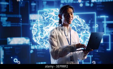 Asian admin in data center using artificial intelligence computing simulating human brain thought processes in computerized model. Employee holding laptop, working with AI machine learning algorithms Stock Photo