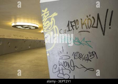 Gloomy underpass on Wiener Platz in Cologne-Muelheim, characterized by cold concrete, circular wall structures and yellowish ceiling lights. The tunne Stock Photo